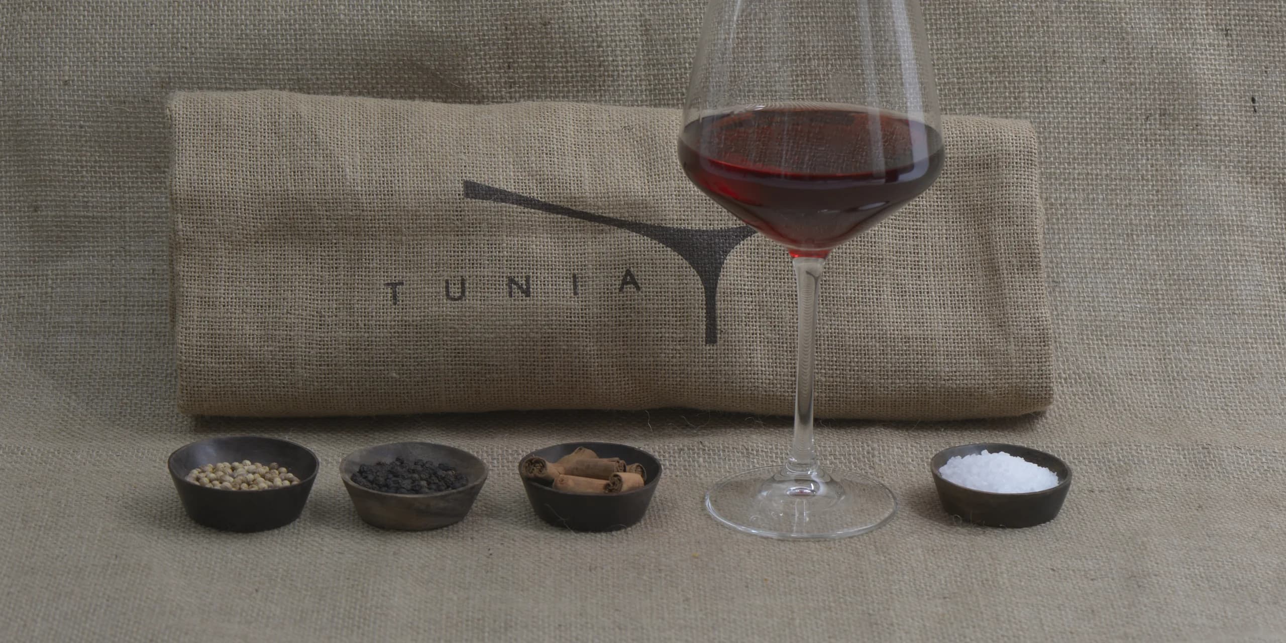 Calice di vino Tunia con le ciotole di spezie sulla iuta